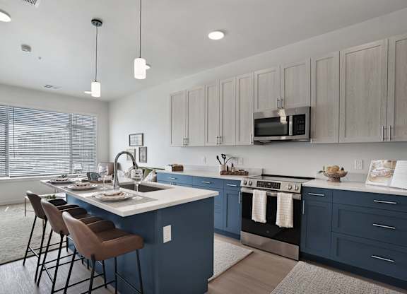 A kitchen with a blue island and wooden cabinets.