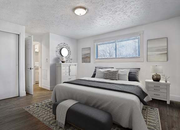 A bedroom with a large bed and a mirror on the wall.