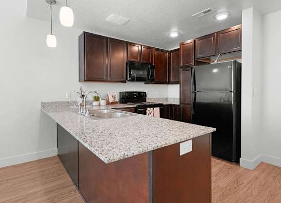 a kitchen with a granite counter top and a black refrigerator