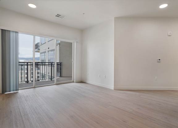 A large empty room with wooden floors and white walls.