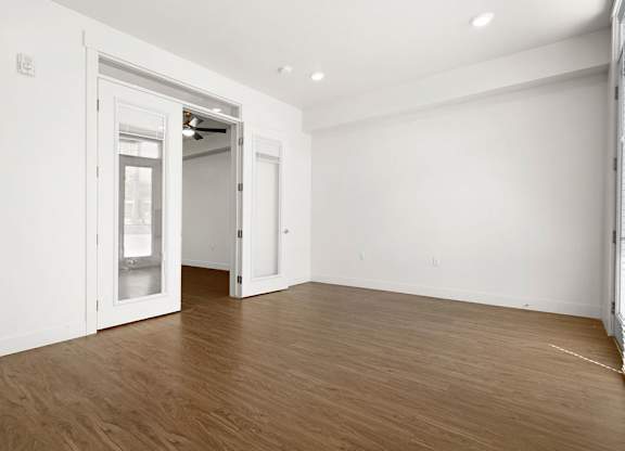 a living room with white walls and wood floors