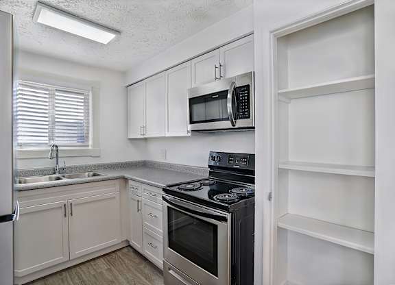 A kitchen with white cabinets and appliances.
