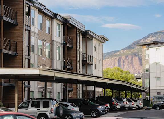 A parking lot with cars and a mountain in the background.