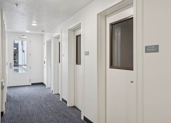 A hallway with doors on both sides and a sign that says 
