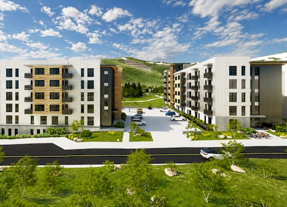 A modern apartment complex with a parking lot in front.