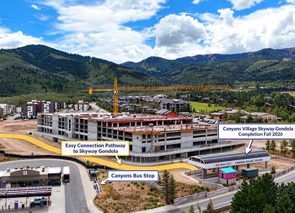 A picture of a road with a building and a sign that says Canyons Village Skyway Gondola.