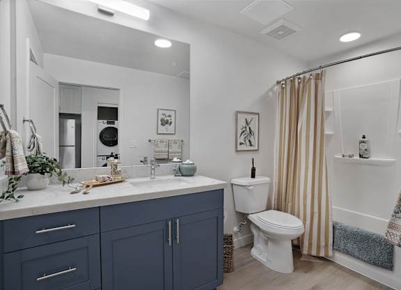 A bathroom with a white toilet, a sink, and a shower.
