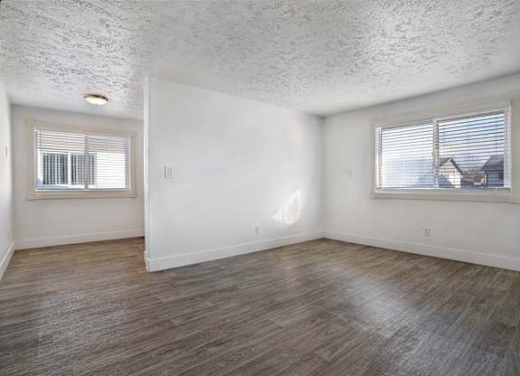 A room with a window and a wooden floor.
