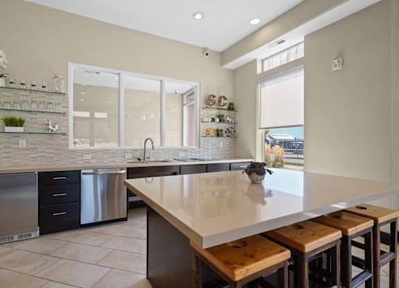 a kitchen with a large island and a table with chairs