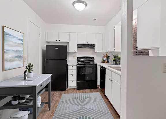 a kitchen with white cabinetry and black appliances
