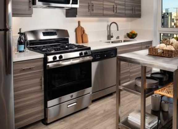 A modern kitchen with stainless steel appliances and wooden cabinets.