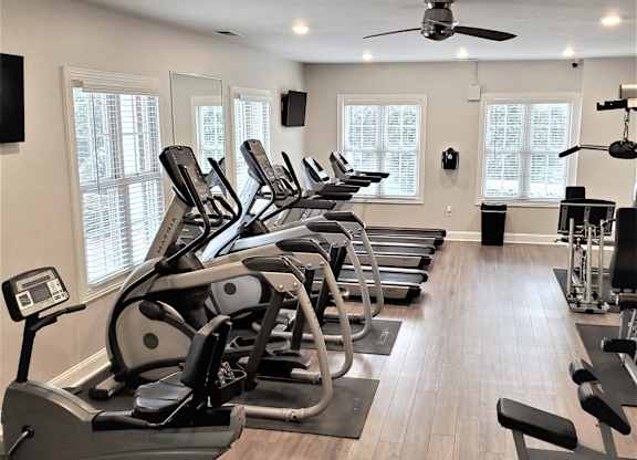A gym with treadmills and elliptical machines.