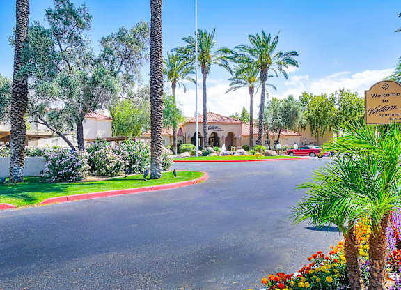 A street view of a residential area with a sign that reads