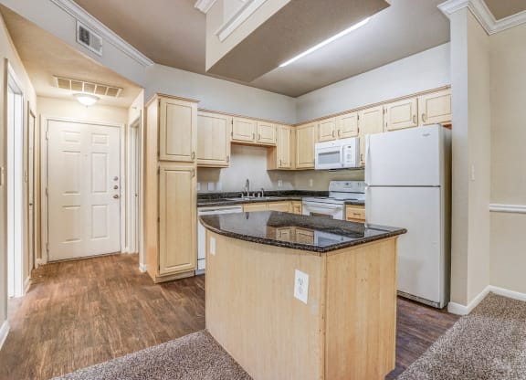 Vacant apartment at Cypress Lake at Stonebriar in Frisco, TX has kitchens with golden oak cabinets and whit eappliances!