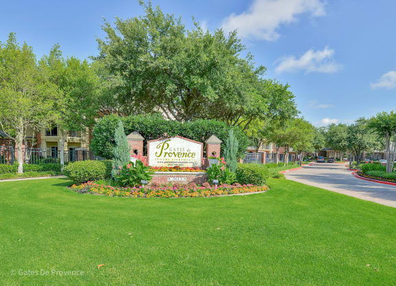 Stone property sign at Gates de Provence Apartments, Dallas 75287