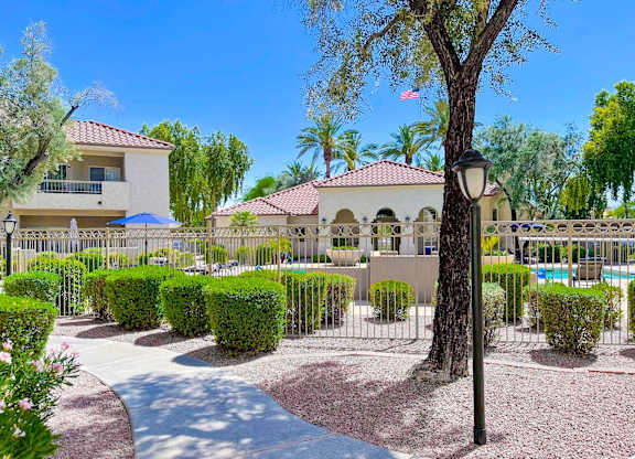A residential area with a house, trees, and a pool.