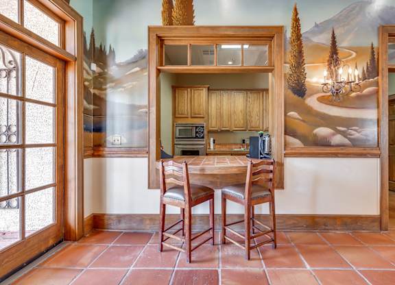 A kitchen with a table and chairs in front of a wall mural.