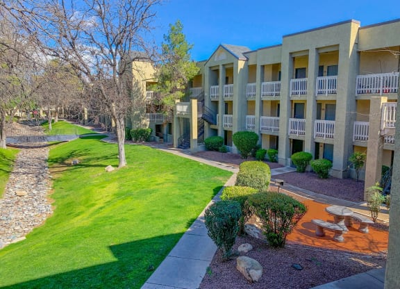 a view of the outside of an apartment building with a yard and grass