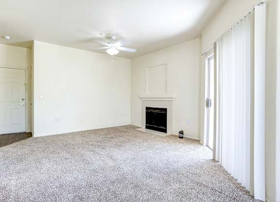 A living room with a fireplace and a carpet.