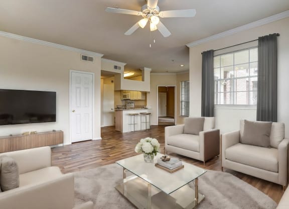 Light and bright living rooms wiith wood flooring at Turnberry Isle Apartments in Dallas, TX.