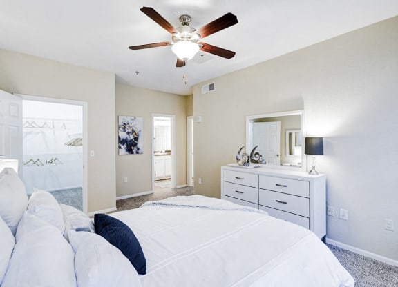 a bedroom with a bed and a ceiling fan