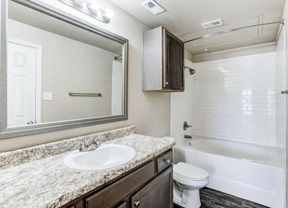 A bathroom with a sink, toilet, and bathtub.