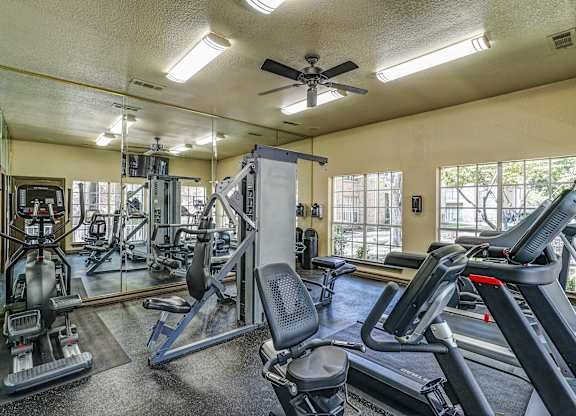 A gym with treadmills, weights, and exercise equipment.