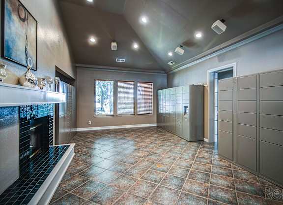 A large, empty room with a fireplace and a tiled floor.