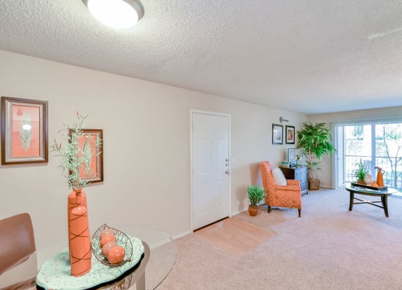 Spacious  living room with a chair and a table and a window