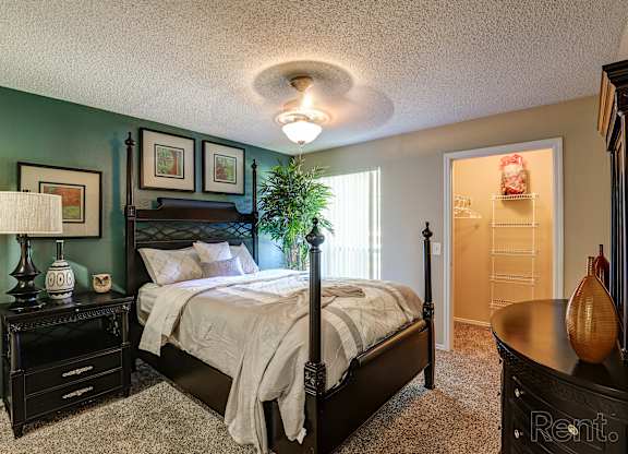A bedroom with a bed, nightstand, and lamp.