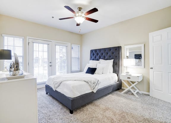 a bedroom with a bed and a ceiling fan