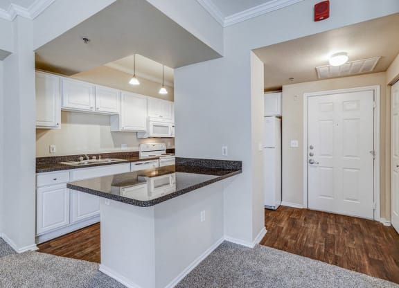 a kitchen with white cabinets and a counter top