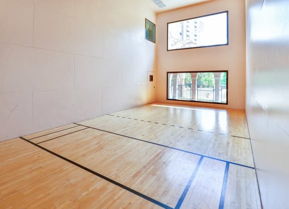 an empty gym with a racquetball court and a window