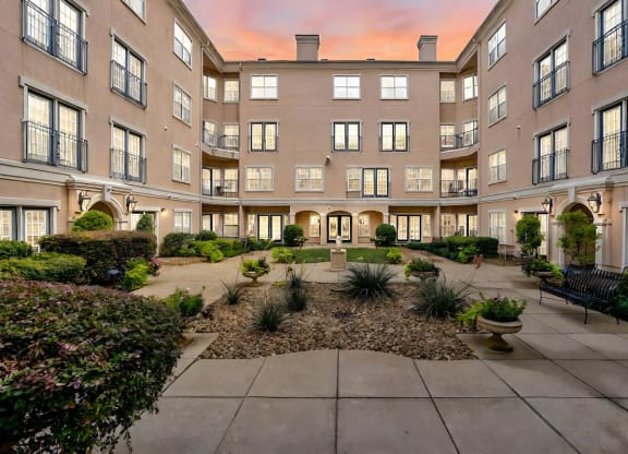 a courtyard with benches and plants in the middle of a building
