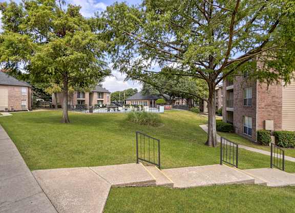 A residential area with apartment buildings and a sidewalk.