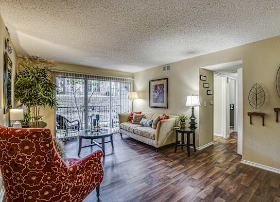 A living room with a red chair and a couch.