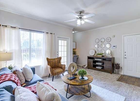 A living room with a brown chair and a white ceiling fan.
