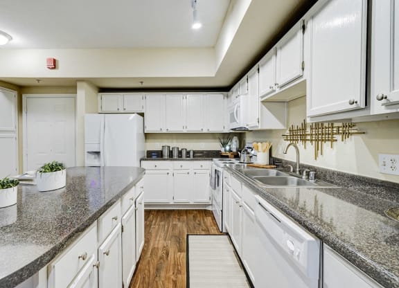a kitchen with white cabinets and granite counter tops