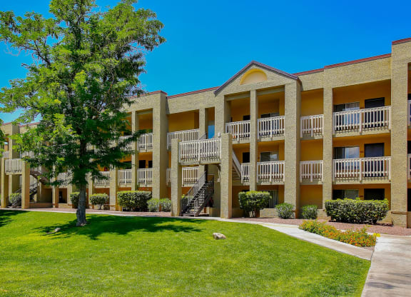 a building with a green lawn and a tree in front of it