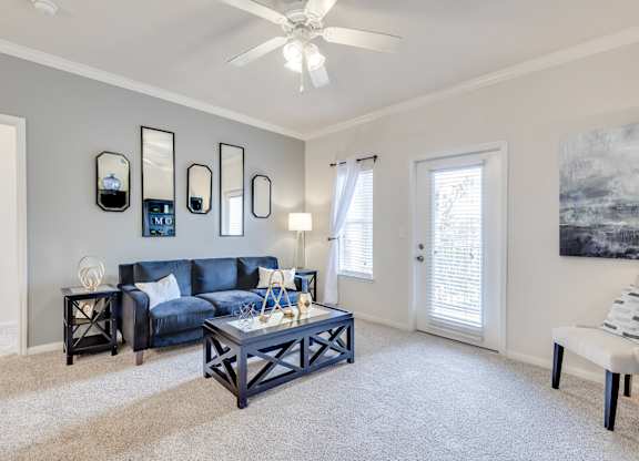 A living room with a blue couch and a white coffee table.