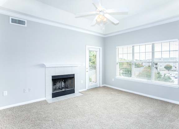 A living room with a fireplace and a ceiling fan.