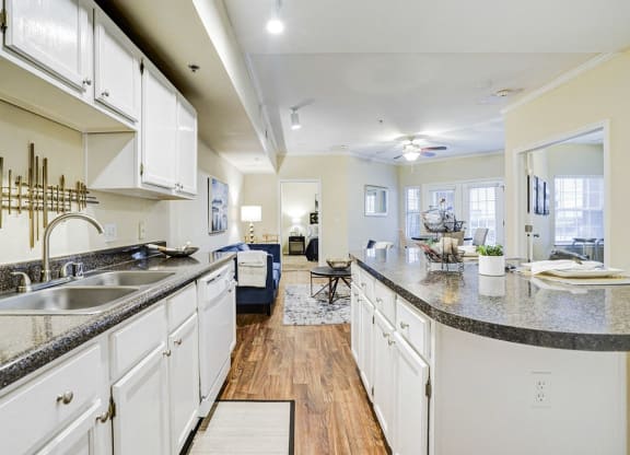 a large kitchen with white cabinets and granite counter tops