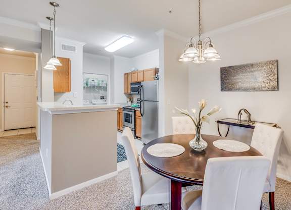 A modern kitchen with a dining table set for two.