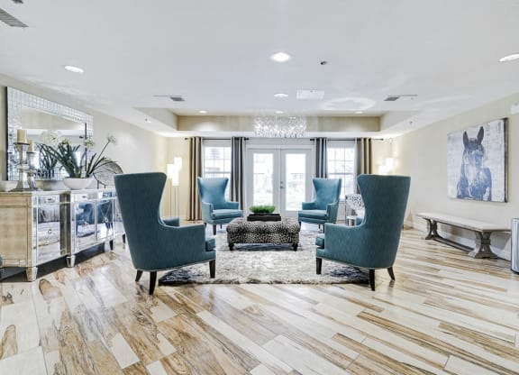 a living room with blue chairs and a rug