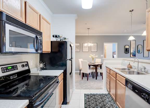 A kitchen with black appliances and wooden cabinets.