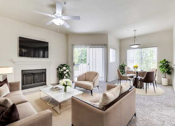 A living room with a fireplace, chairs, and a television.
