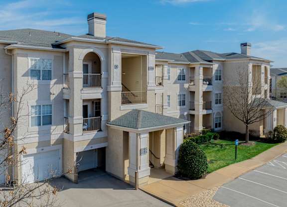 Apartment complex with a parking lot in front.