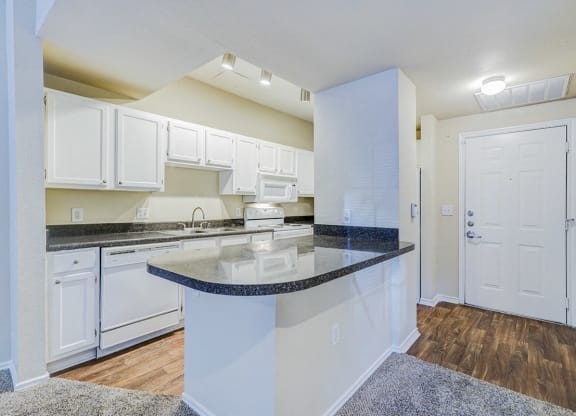 a kitchen with white cabinets and a counter top