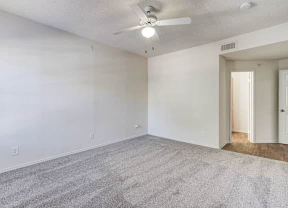 Another view of the spacious bedroom at Saxony at Chase Oaks Apartments in Dallas, TX, with a walk-in closet and ceiling fan.