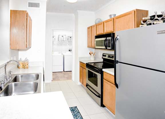 A modern kitchen with a stainless steel refrigerator, microwave, and oven.